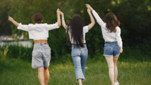 Mujeres felices, en el campo levantando las manos