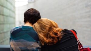 Mujer recostada en hombro de su pareja en empatía