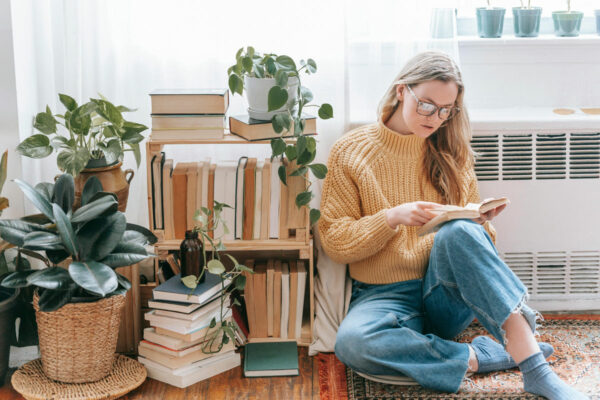 Mujer leyendo un libro en la biblioteca de la casa.