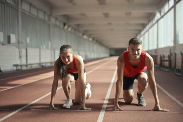 Mujer y hombre listos para competir en una carrera