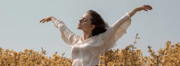 Mujer con los brazos abiertos recibiendo el viento